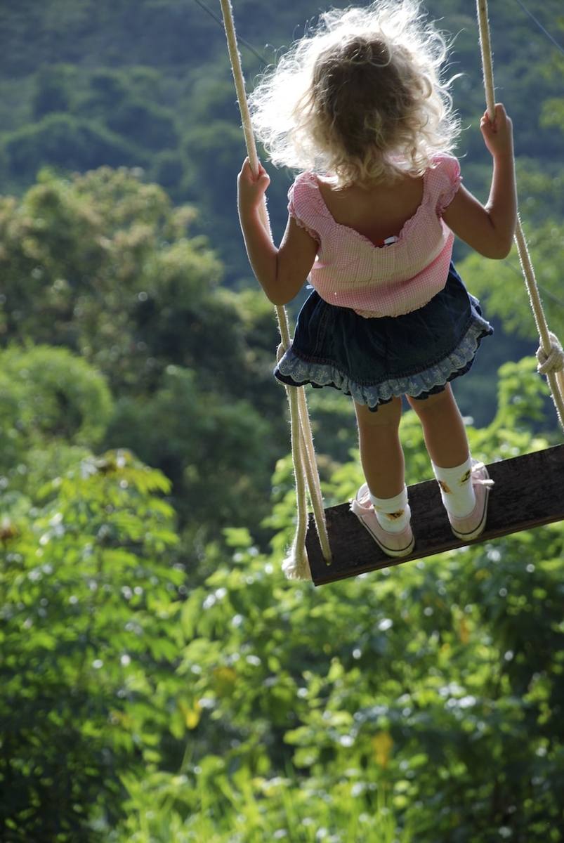 Criança no balanço nos jardins do Casarão Penedo
