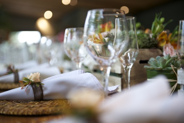Mesa elegante decorada para evento no Casarão Penedo — taças de cristal, guardanapos e arranjos florais