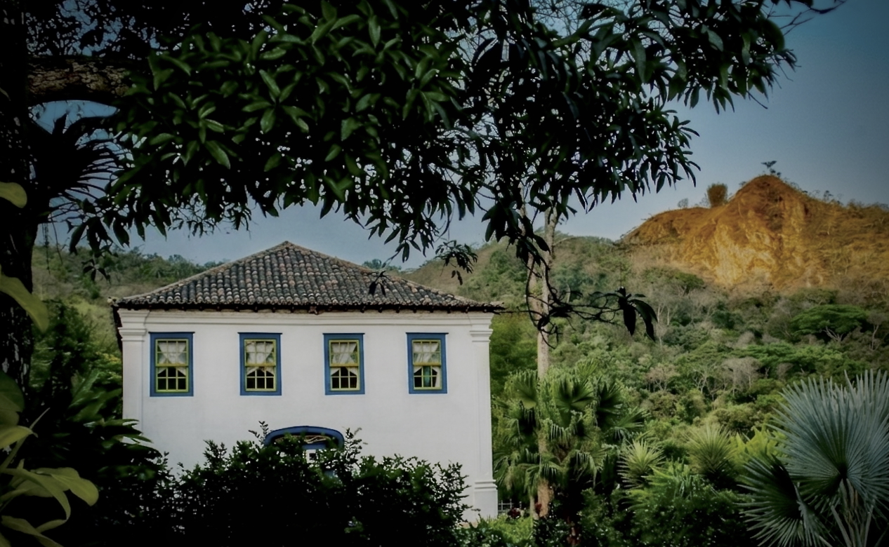 Casarão Penedo ao entardecer com Pico do Penedo dourado ao fundo