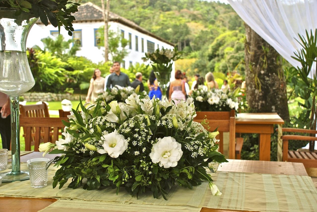 Decoração de casamento com flores e casarão ao fundo