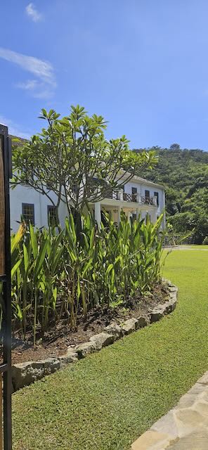 Jardins e fachada do Casarão Penedo com serra ao fundo