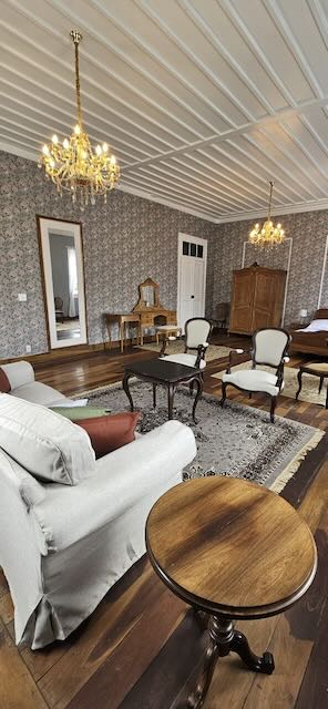 Suite da Noiva com lustres de cristal e papel de parede floral no Casarão Penedo