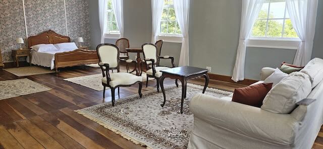 Suite da Noiva com mobiliário clássico e piso de madeira no Casarão Penedo