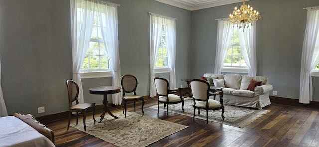 Sala da Suite da Noiva com lustre de cristal e poltronas no Casarão Penedo