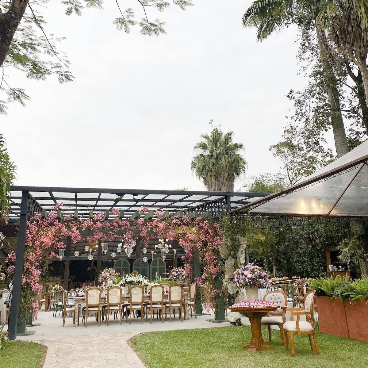 Pérgola com flores e decoração para jantar no jardim do Casarão Penedo