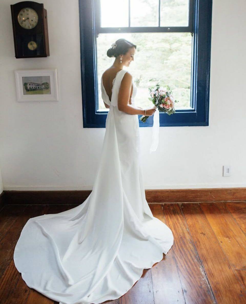 Bride in the Bridal Suite at Casarão Penedo with bouquet by the window