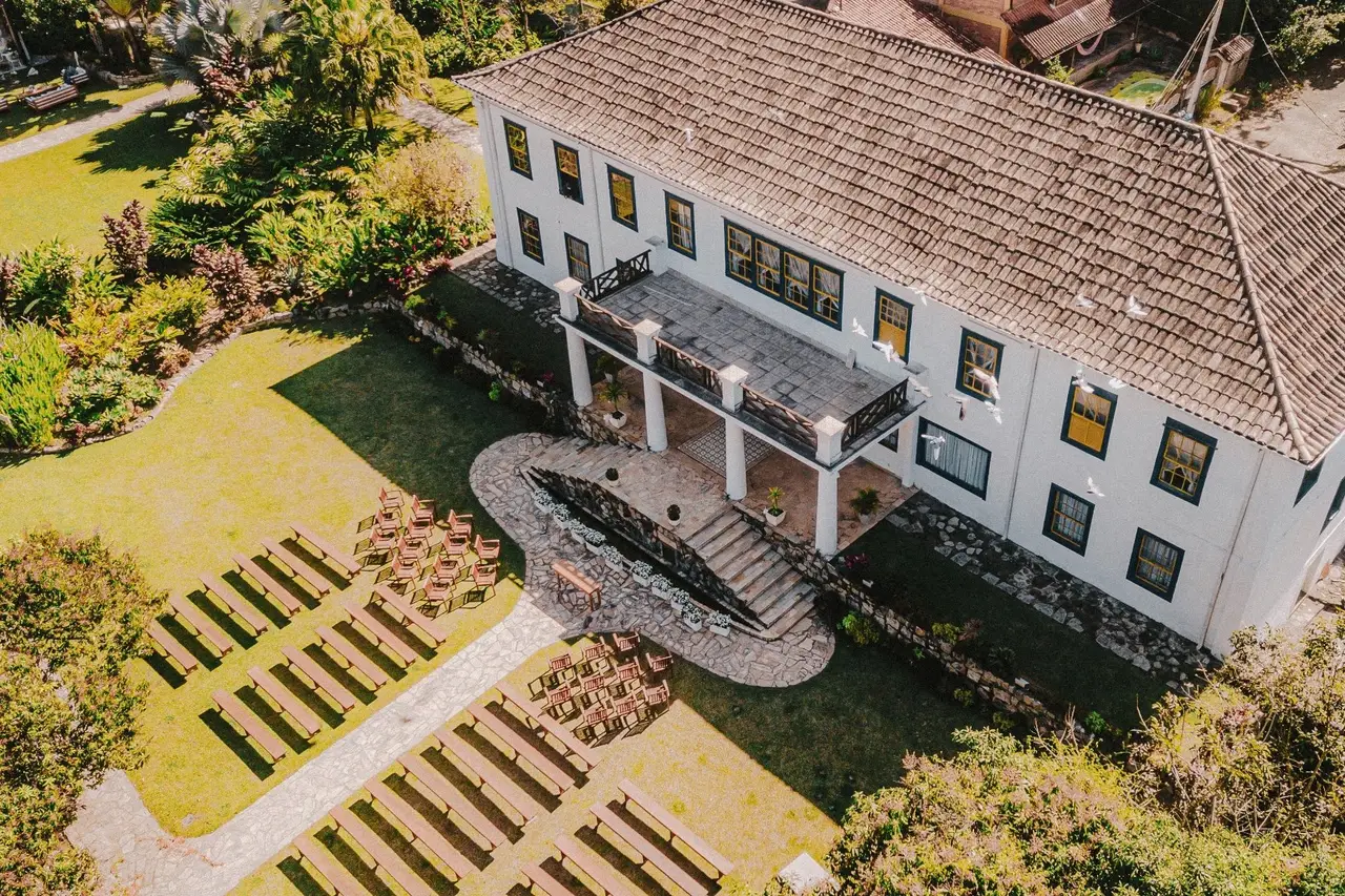 Vista aérea do Casarão Penedo com gramado e cadeiras para cerimônia ao ar livre